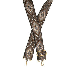 You'll love changing up the style of your purse with one of our guitar straps! This beautifully embroidered strap has embroidered diamonds in black, gold, grey, and white. The back of the strap is solid black.  35"-54" adjustable length  2" wide  Brass plated hardware