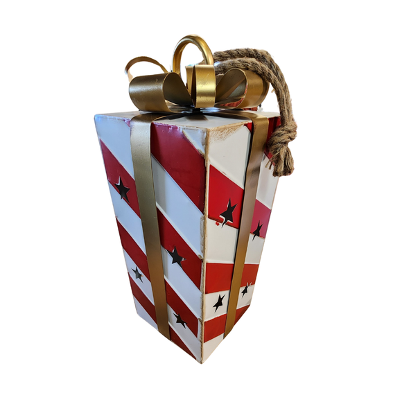 You'll love adding this festive red and white distressed striped package with a gold ribbon in it. There are star cutouts along all sides that let light from a LED votive or battery powered candle show through (there is no base, so it is easy to just sit on top of your light source). At the top is a gold ring at the center of the bow in case you would like to hang.

Approximatly 7.5