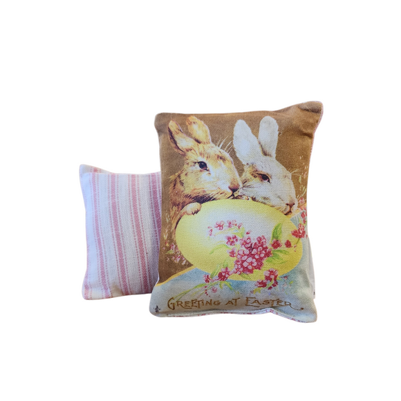 This adorable mini vintage postcard pillow has a brown and white bunny leaning on a yellow egg with 