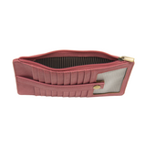 This slim and sleek wallet has nine credit card pockets, each with a snap tab for security and brass-plated hardware. It also has an ID window, zippered change pocket, and zippered billfold pocket in distressed pink punch vegan leather.


DIMENSIONS: 3.75 IN. H X 7.25 IN. W X .25 IN. D&nbsp;


100% Vegan leather (polyurethane)