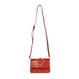 Put a ring on it! Perfect for your next night out, this cute red bracelet bag looks great with your fav jeans or slinky dress! With multiple compartments, it is just the right size to hold all your essentials. Wear it on your wrist with the metallic ring bracelet, or carry as a clutch, or wear as a crossbody with the detachable shoulder strap.


Dimensions: 6 in. H x 8.25 in. W x 3.5 in. at deepest point
Tapers up to the top point
Adjustable and removable crossbody strap: 20-25 in.
3 in. diameter ring that 
