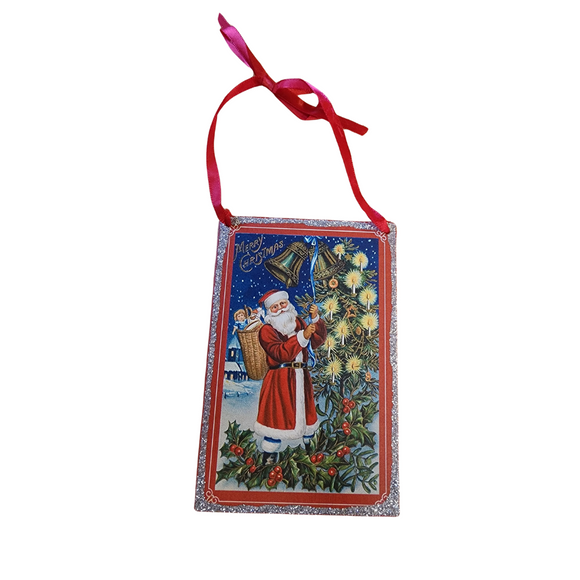 Bring a little nostalgia to your holiday decor this year with this vintage rectangle shaped ornament that has Santa decorating the tree! It has silver glitter on the outside border and a red ribbon to hang it with.

6