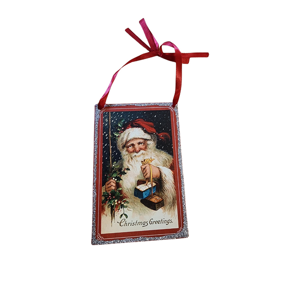 Bring a little nostalgia to your holiday decor this year with this rectangle shaped vintage ornament that has Santa holding gifts and says 