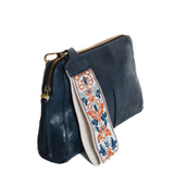 Retro styling crafted in antiqued vegan leather gives this dark indigo clutch a vintage vibe. The removable woven wrist strap is the finishing touch on this stylish bag so you can wear it as a wristlet, a clutch, or a crossbody with the included removable shoulder strap!





6.75"H x 9.75"W x 2.25"D

Removable and adjustable crossbody strap 22"-26"

Removable long wristlet strap 7.5" long

Zippered top closure

Interior zippered pocket

Exterior back zipper pocket

Brass plated hardware

100% vegan leather