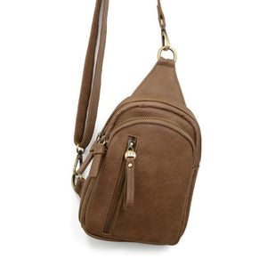 Blending uptown chic with downtown cool, the Skyler sling bag is made in rich vegan taupe leather! A convertible strap lends versatility, while a front zip pocket offers practical storage for your necessities. It is the perfect companion for a night out on the town or a fun day trip!   8" h x 5.5" w&nbsp; x 2.25" d