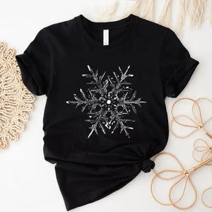 Let it snow! This gorgeous white snowflake is printed on a soft &amp; comfy black t-shirt. You will love wearing it to get-togethers, shopping, or just running around doing errands. The styling possibilities are endless. Roll up the sleeves, tie a side knot, front tuck, or wear it while lounging around the house.&nbsp;