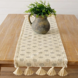 This pretty cream-colored runner is all about texture (and you know how we LOVE texture in our homes!) It has a beautiful grey medallion print going down the runner.  The frayed edges go down the runner, and on the ends are cream tassels.  It will make your table look GORGEOUS!   56" L x 13" W