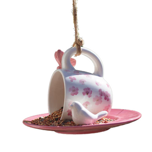 Here's the cutest thing you'll hang up this year for your birds! This sweet ceramic teacup birdfeeder has a white teacup with pink flowers scattered all over it in its side on a pink saucer. There is a pink butterfly on top by the handle and a white ceramic bird along the right hand side of the cup that is sitting on the saucer.

7.5”d x 5.5”t

Wipe clean with a lint free, dry cloth.