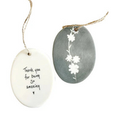 We love our porcelain ornaments because they are perfect for gift-giving! This oval ornament says, "Thank you for being so amazing," with a heart beneath on one side. The other side has a grey background with a&nbsp;branch running the center with&nbsp;flowers all in white.


Dimensions:&nbsp;2" W x 2 3/4" H
