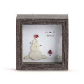 This sweet shadow box from Sharon Nowlan is perfect for decorating a small spot! It features artful craftsmanship and has a snowman made out of sea glass with two red birds, also out of sea glass. One bird is on the snowman's head, the other is on the ground looking up at the other bird.  The words "make it merry" are in a type font above to the right.  4"w x 2"d x 4"h