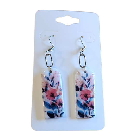 You will love these lightweight, trendy polymer watercolor floral arched earrings! Pink. red, and gold flowers with blue accents embellish the white background create a stunning design! The earring hooks are comfortable and easy to wear and coated with a resin layer to give them a pretty shine and finished look. The hooks are made of high-quality, strong/durable stainless steel, which is hypoallergenic and nickel-free. * 

This versatile earring design would accompany any outfit, from casual to dressed