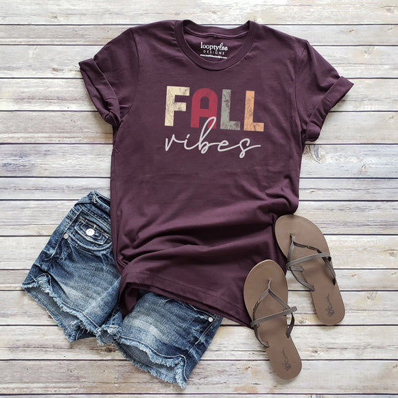 Our Fall Vibes T-shirt is a deep shade of plum with the words 