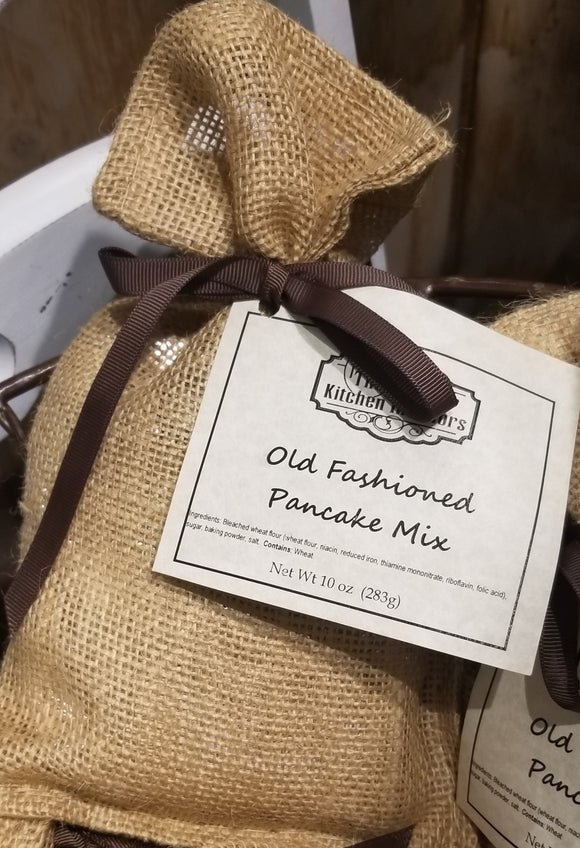 a burlap bag with a brownribbon tying a cream tage saying Old Fashioned Pancake Mix on it