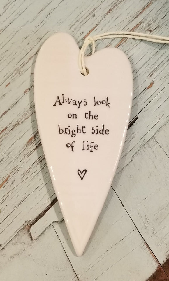 a porcelain white heart shaped ornament with a white cord to hang with the words 