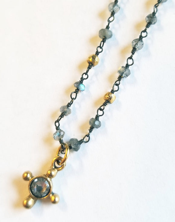 Our North Star Necklace is inspired by that one thing that motivates you. The thing you turn toward in your darkest time.  Made from Labradorite beaded chain with an artisan brass star and Swarovski pendant. 16