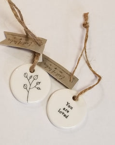 These little porcelain tags are as cute as can be. With a sentiment on one side and a branch with leaves on the other, they have a cord that can be put on a bag or put into a card to give to someone.  1 1/4" Dia