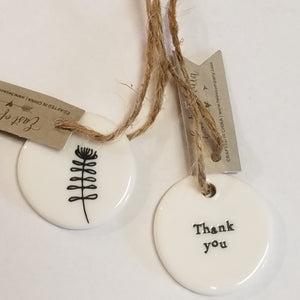 These little porcelain tags are as cute as can be. With a sentiment on one side and a branch with a leaf on the other, they have a cord that can be put on a bag or put into a card to give to someone.  1 1/4" Dia