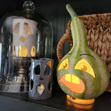 This grouchy gourd has vintage-style printed vellum inserts with an opening in the bottom for a battery-operated light. Light him up for a glowing good time at your Halloween Soiree!  Paper mache and vellum.  Approximately 9.5" X 5.25" X 5"