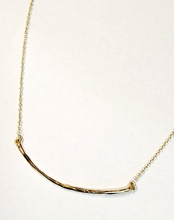 Organic hammered bar necklace in brass and is attached to a chain. The adjustable chain can go from 16