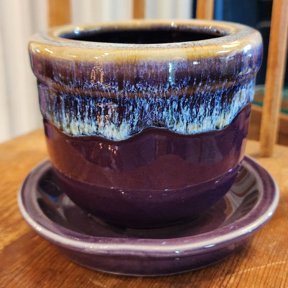 This pretty purple stoneware pot has a pretty drip design along the edge! It comes with a matching saucer and has a drain hole at the bottom of the pot. Stick one of your favorite plants (or artificial) in it and put it in a spot where you'll see it ~ it will surely make you smile!   3 1/2