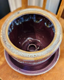 This pretty purple stoneware pot has a pretty drip design along the edge! It comes with a matching saucer and has a drain hole at the bottom of the pot. Stick one of your favorite plants (or artificial) in it and put it in a spot where you'll see it ~ it will surely make you smile!   3 1/2" H x 4" Di