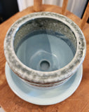 This pretty blue stoneware pot comes with a matching saucer and has a drain hole at the bottom of the pot. Stick one of your favorite plants (or artificial) in it and put it in a spot where you'll see it ~ it will surely make you smile!   3 1/2" H x 4" Dia
