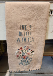 This sweet little tan-colored tea towel has an embroidered teacup in blue on the front with flowers in shades of pink, green, and white along with green leaves, all springing out of it.  Above it says, "Life Is Better With Tea" in blue.  It is a perfect accessory for any tea lover!  20" x 26"  Cotton, Linen. Machine-Washable.