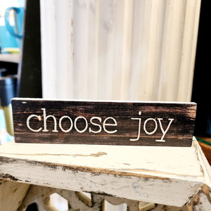This a good reminder to keep focused on the good things! This mini sign has a black distressed background with the words "choose joy" in a white type font.   Wood Depth: 0.4375" Width: 6" Height: 1.5"