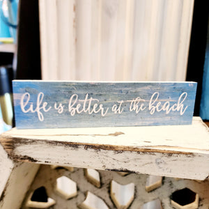 For SURE!! This turquoise distressed mini sign has the words "life is better at the beach" written in a white cursive font.  Wood. Depth: 0.4375" Width: 6" Height: 1.5"