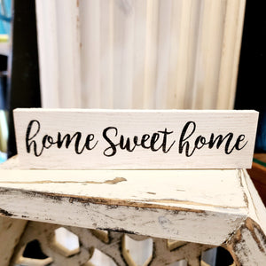 This mini sign has a whitewashed wooden background with the words: "home Sweet home" written in a black cursive font.  Wood Depth: 0.4375" Width: 6" Height: 1.5"