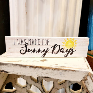 How HAPPY!  "I was made for Sunny Days"  is written in a black mixed font on a whitewashed wood background with a bright yellow sun shining on the right-hand side!  Wood Depth: 0.4375" Width: 6" Height: 1.5"