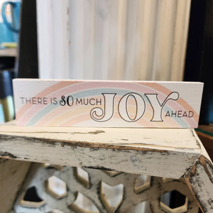 Such a sweet sign! This mini sign has a cream background with a pastel rainbow background.  It then says, "There is SO Much JOY Ahead" in a black mixed font.  Wood  Depth: 0.4375" Width: 6" Height: 1.5"