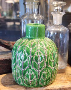 This beautiful green vase is embossed with a pretty leaf design. It will be sure to add a botanist flair to your home. Place your favorite fresh flower inside for an additional pop of color.  3-3/4"H