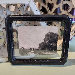What a fun picture to display on your wall, bookcase, or picture frame! It has a distressed black frame with a vintage reproduction landscape floating in the frame. The black and white watercolor picture has a road with a horse with a rider and another figure walking beside with trees off to the right.   8-1/4"W x 7"H