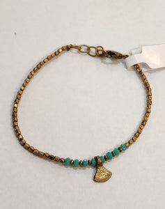 We love this triangle drop bracelet with turquoise and brass beads! Layer it with more of our brass bracelet collection. It has a lobster clasp closure with several links to choose from for the right fit!   Our brass collection is a mix of handmade pieces and cast designs, with all details hand carved. Made by skilled metal smiths in the Rajasthan region of Northern India. The brass we use combines zinc and copper and is nickel-free.  Approximately 7"  Made in India