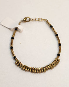 We love this bracelet with black and brass beads and longer brass beads in the center. Our brass collection is a mix of handmade pieces and cast designs, with all details hand carved. Made by skilled metal smiths in the Rajasthan region of Northern India. The brass we use combines zinc and copper and is nickel-free.  Approximately 7"  Made in India