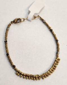 We love this bracelet with grey and brass beads and longer brass beads in the center. Our brass collection is a mix of handmade pieces and cast designs, with all details hand carved. Made by skilled metal smiths in the Rajasthan region of Northern India. The brass we use combines zinc and copper and is nickel-free.  Approximately 7"  Made in India