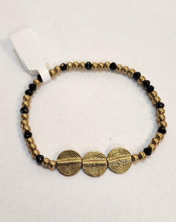 We love this bracelet with black and brass beads. It has three circular brass discs in the center of the bracelet. Our brass collection is a mix of handmade pieces and cast designs, with all details hand carved. Made by skilled metal smiths in the Rajasthan region of Northern India. The brass we use combines zinc and copper and is nickel-free.  Approximately 7