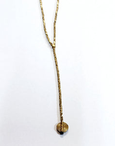 Simplicity is always good! This beautiful lariat necklace is made up of small brass faceted beads at the bottom of the necklace hangs a single 4.5" strand with a round brass charm. You'll love how the light bounces off of this necklace!  The necklace hangs down 21" in total  Handmade by a young designer and team of artists in Northern India