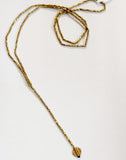 Simplicity is always good! This beautiful lariat necklace is made up of small brass faceted beads at the bottom of the necklace hangs a single 4.5" strand with a round brass charm. You'll love how the light bounces off of this necklace!  The necklace hangs down 21" in total  Handmade by a young designer and team of artists in Northern India