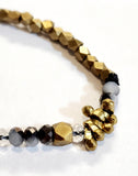 Gorgeous! This necklace is just a fun piece and a new favorite at The Summer Kitchen. It has beautiful brass small diamond-shaped beads mixed with faceted black, clear, and grey-toned beads and a few brass toggled beads thrown in for fun.  Lots of light plays off of this necklace!   We even like to double this one up to create a layered look as well!  50" beaded necklace hangs down 25" long  Handmade by a young designer and team of artists in Northern India