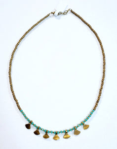 This gold beaded necklace with turquoise glass beads has 7 gold triangle shapes hanging from the bottom. It is pretty to wear alone but looks great layered with one of our longer brass necklaces!  Handmade by a young designer and team of artists in Northern India.  17"-18" Adjustable necklace 