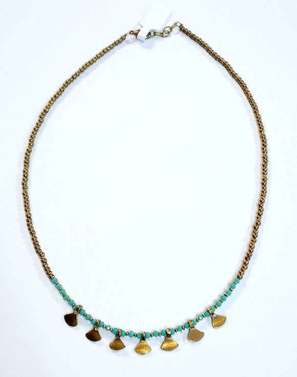 This gold beaded necklace with turquoise glass beads has 7 gold triangle shapes hanging from the bottom. It is pretty to wear alone but looks great layered with one of our longer brass necklaces!  Handmade by a young designer and team of artists in Northern India.  17