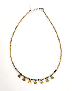 This gold beaded necklace with gray multicolored glass beads has 7 gold triangle shapes hanging from the bottom. It is pretty to wear alone but looks great layered with one of our longer brass necklaces!  Handmade by a young designer and team of artists in Northern India.  17"-18" Adjustable necklace 