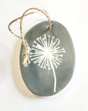 We love our porcelain ornaments because they are perfect for gift-giving! This oval ornament says, "You are my sunshine, my only sunshine.  You make me happy when skies are grey" on one side. On the other side is a grey background with a white dandelion puff.   Dimensions: 2" W x 2 3/4" H