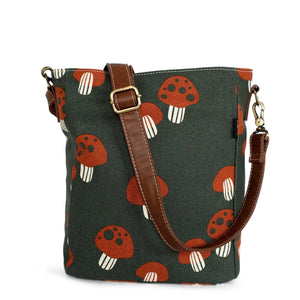 The cutest mushrooms adorn our fanny pack! The burnt-orange and cream mushrooms are scattered on top of a pine-colored background. All of our bags are printed on recycled canvas with eco-friendly pigment inks. The City Sling It fits an iPad, your wallet, smartphone, and essentials, yet is lightweight enough for everyday use, day trips, errands, etc. Features an adjustable vegan leather strap, waterproof interior lining, and 1 zippered pocket for added security.  Dimensions: 8.5" x 11" x 3" Strap Drop: 22"