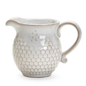 This little pitcher is ever so sweet!  It is hand glazed with a soft, translucent glaze showing off the beautiful stoneware and the bee stamped above the pretty honeycomb design all around the creamer. It is dishwasher-safe.   Stoneware    5" W x 3.25" D x 3.75" H
