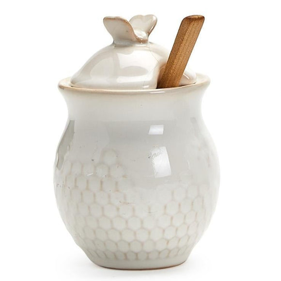 This sugar jar is ever so sweet!  It is hand glazed with a soft, translucent glaze showing off the beautiful stoneware and the bee stamped above the pretty honeycomb design all around the jar. The jar is dishwasher-safe. Please hand wash the spoon.  Stoneware (jar) and Nanmu Wood (spoon)  Jar: 4.75