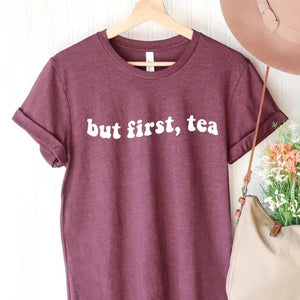 We know you're a tea lover, but does anyone else?  If you drink tea as we do, you will love wearing this "But First, Tea" t-shirt!  The white lettering is on a plum-colored t-shirt. Pair it with your favorite jeans and flats!  SIZING Unisex. The fit is more relaxed than typical women’s shirts fit.  CARE - Turn the garment inside out and wash cold on a delicate cycle. - Lay flat to dry. - Do not bleach, dry clean, or iron directly onto the design. Made in Canada
