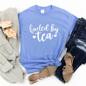 We know you're a tea lover, but does anyone else?  If you drink tea as we do, you will love wearing this "Fueled by Tea" t-shirt!  The white lettering is on a beautiful Carolina blue t-shirt. Pair it with your favorite jeans and flats!  SIZING Unisex. The fit is more relaxed than typical women’s shirts fit.  CARE - Turn the garment inside out and wash cold on a delicate cycle. - Lay flat to dry. - Do not bleach, dry clean, or iron directly onto the design. Made in Canada